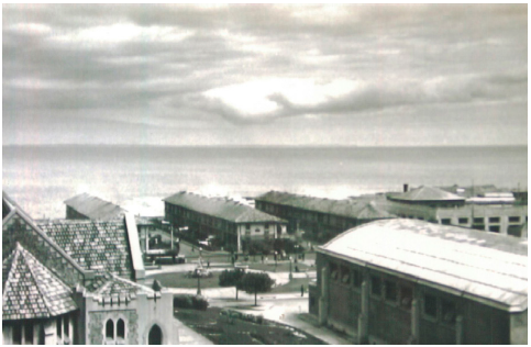 Vista de la plaza desde Cerro Palomares. En primer plano se observan la iglesia y las ruinas del gimnasio, y al fondo el mar.