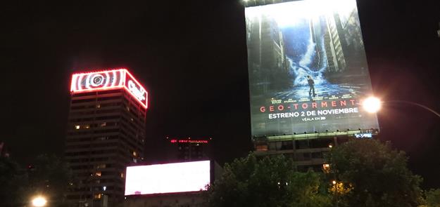 Vista nocturna actual del sector de Plaza Baquedano (vista a Torres San Borja desde metro estación Baquedano). Se aprecia la coexistencia de diversas formas de publicidad lumínica: iluminación eléctrica, letrero de neón y pantalla led.